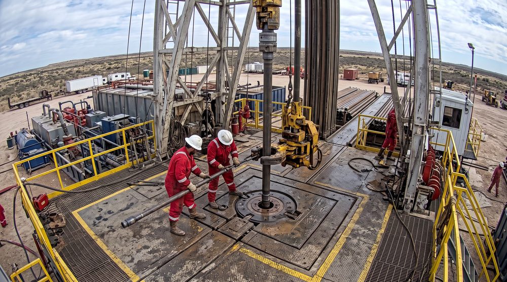 Drill floor seen from above with two crew members at the rotary table