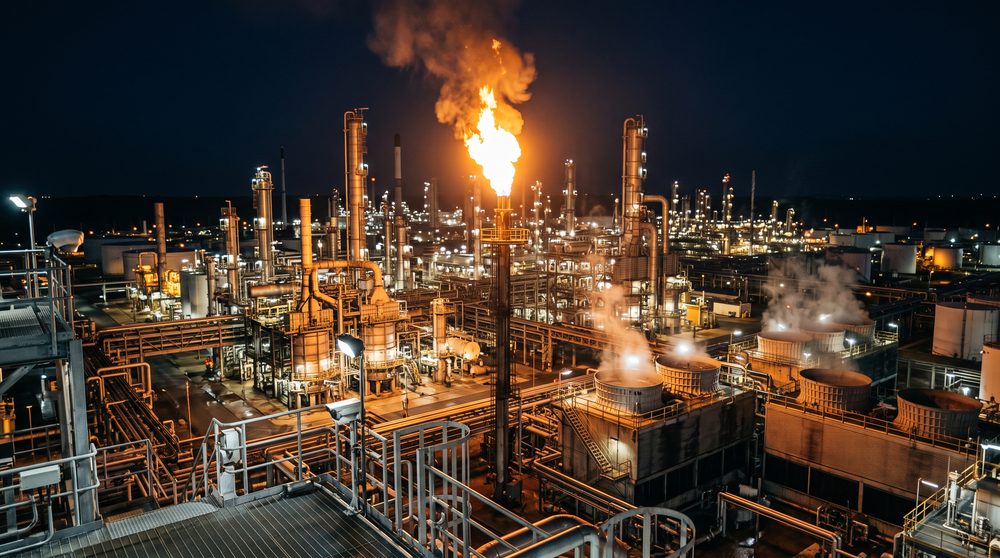Refinery at night with a flare burning over the process units